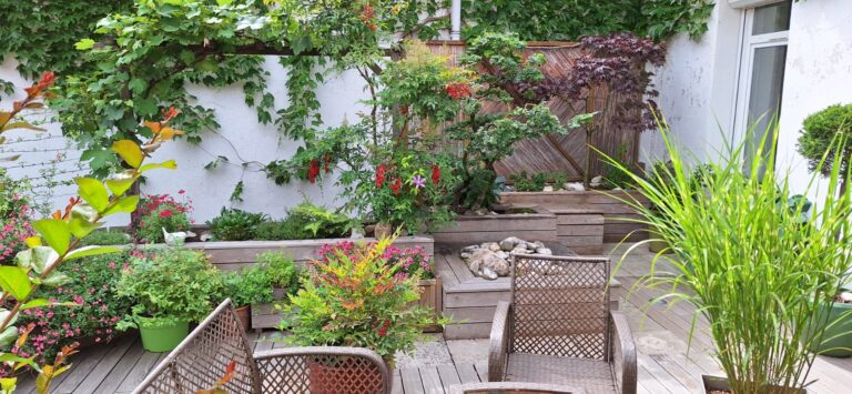 Bacs fleuris et graminées autour du salon de jardin après la remise en état