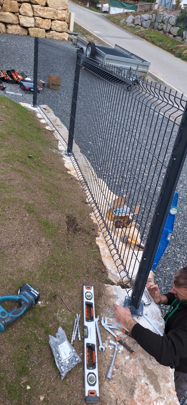 Fixation des poteaux de clôture sur platines dans les blocs de pierre, pendant la pose