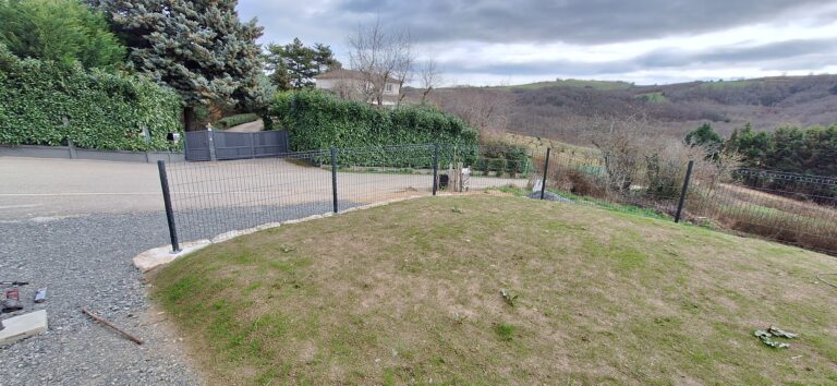 Clôture en panneaux rigides suivant la courbe du jardin, avec vue sur la vallée