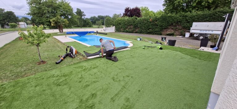Pose et collage du gazon synthétique le long des margelles de la piscine