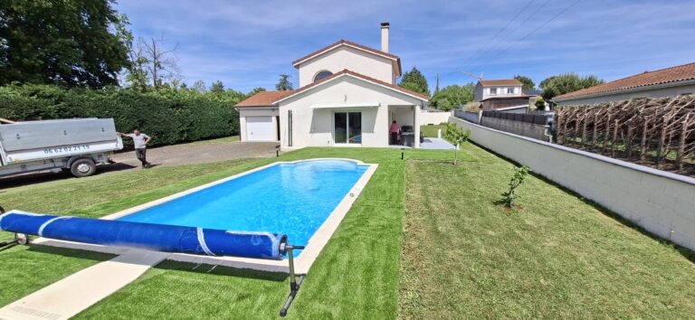 Gazon synthétique posé autour d'une piscine, avec vue sur la maison, à Sury-le-Comtal